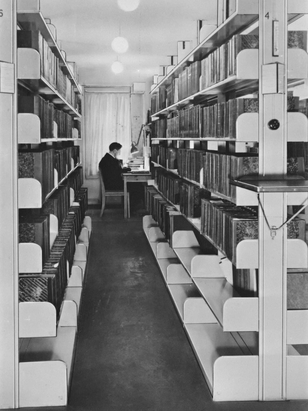 A reading room with one person working at the far end